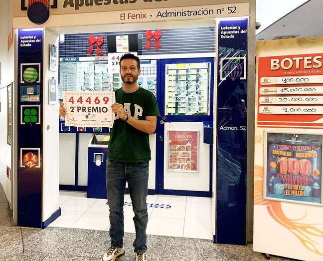 Moisés Moreno, uno de los gerentes de la Administración El Fénix, muestra el cartel del número premiado/TA.